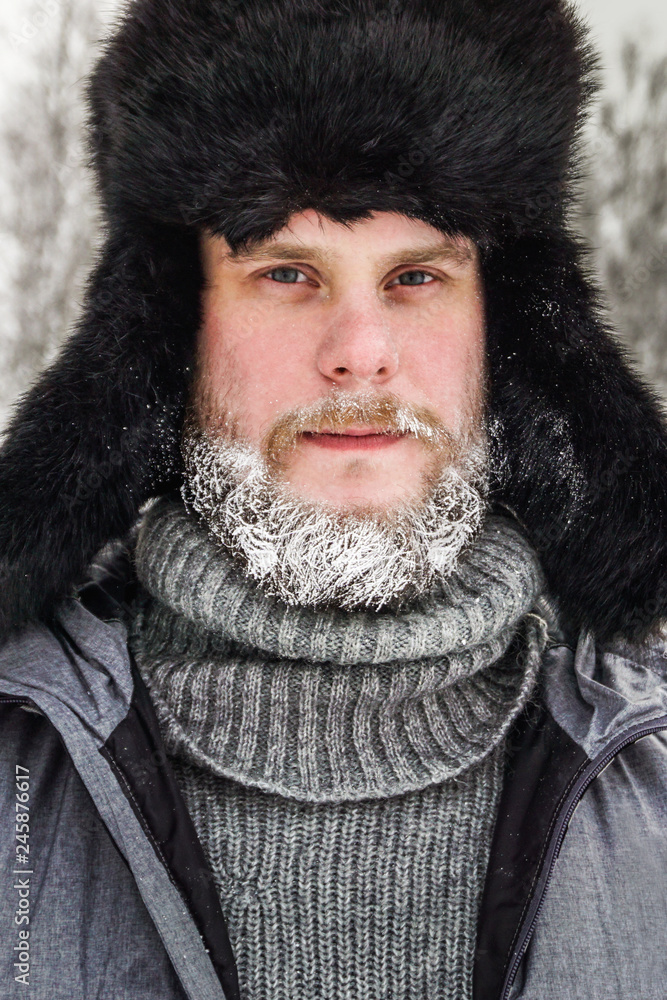 frozen man with a beard in winter in a forest with snowdrifts fell ill from the cold after a walk in the village frozen man with a beard in winter in a forest with snowdrifts fell ill from the cold after a walk in the village