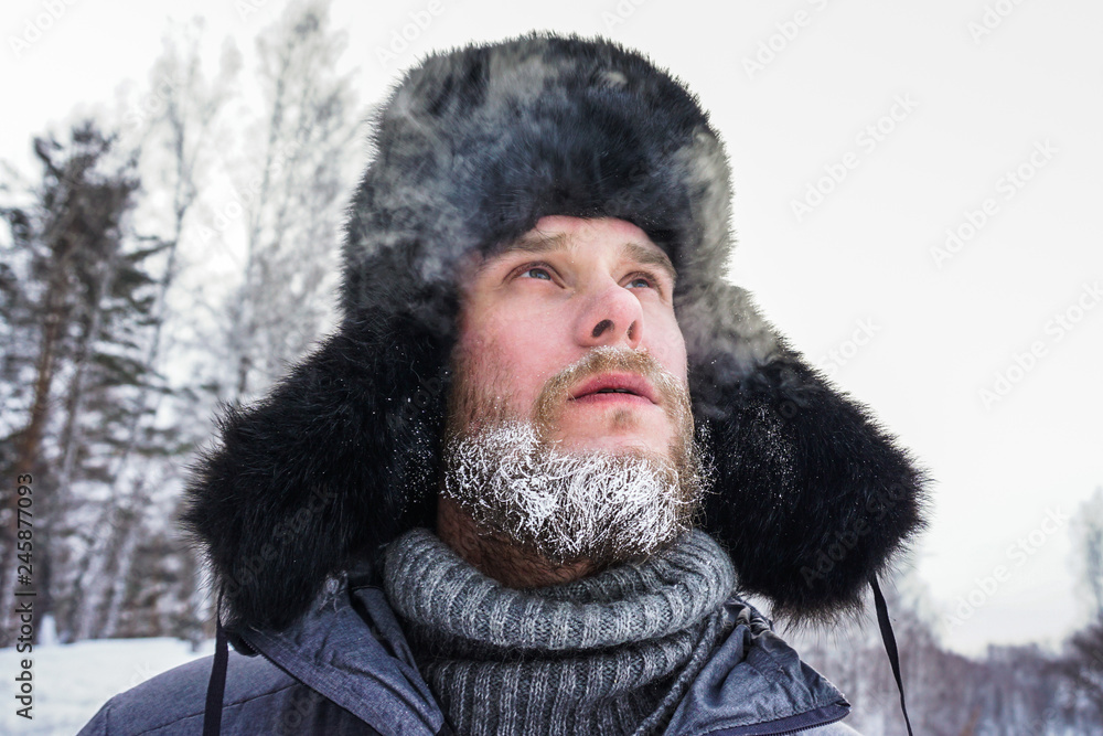 frozen man with a beard in winter in a forest with snowdrifts fell ill from the cold after a walk in the village frozen man with a beard in winter in a forest with snowdrifts fell ill from the cold after a walk in the village