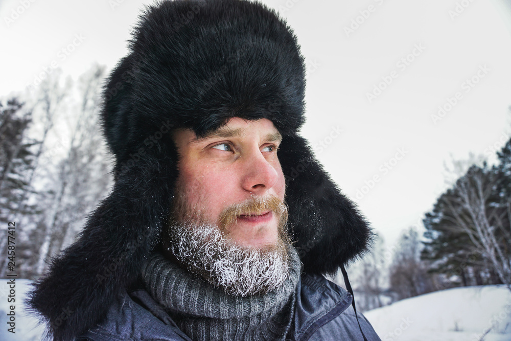 frozen man with a beard in winter in a forest with snowdrifts fell ill from the cold after a walk in the village