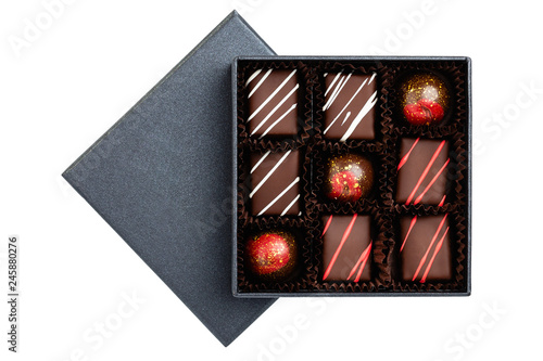 Assortment of luxury bonbons with redl splashes in black box isolated on white background photo