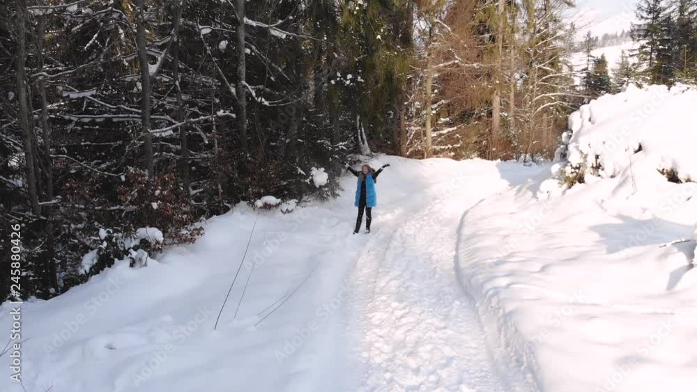 Young beautiful girl walks in the snowy winter forest. She is happy and cheerful. The girl throws snow over her head. Shooting from the quadcopter. Slow motion. Young beautiful girl walks in the snowy winter forest. She is happy and cheerful. The girl throws snow over her head. Shooting from the quadcopter. Slow motion.