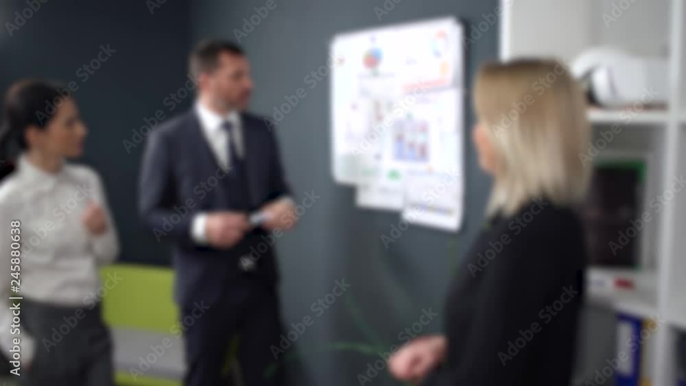 Blurred view, businessman gives instructions to womens managers, teamwork in office interior. Blurred view, businessman gives instructions to womens managers, teamwork in office interior.