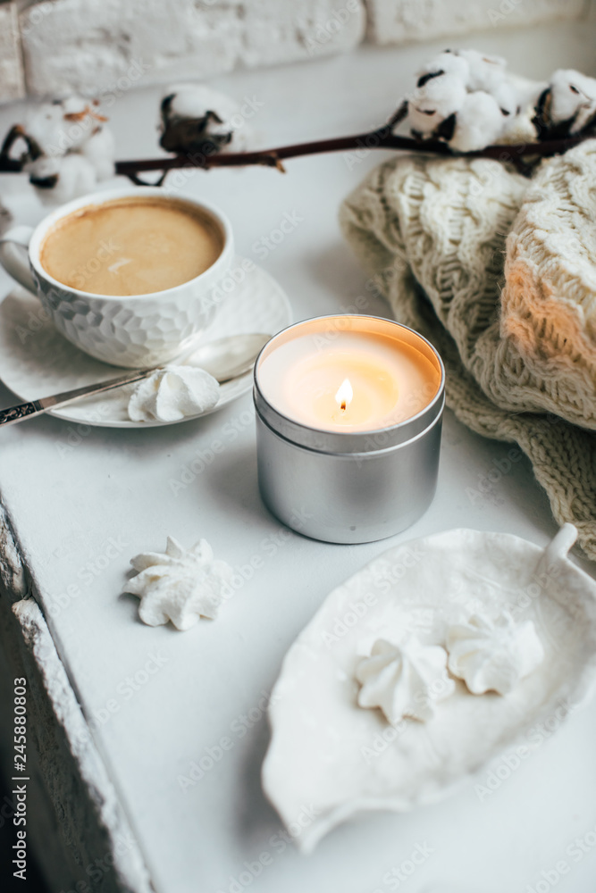 Cozy winter home interior with knitted blanket and candle Cozy winter home interior with knitted blanket and candle