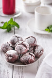 Red velvet cookies on a white table, white cups and mint
