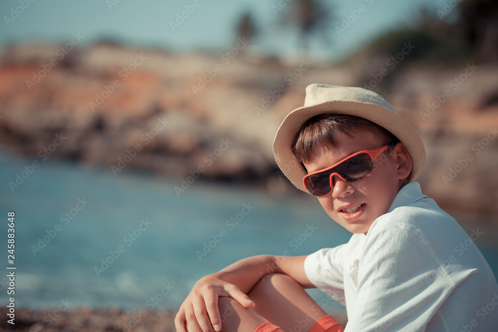 Portrait of teenager sitting near sea, outdoor