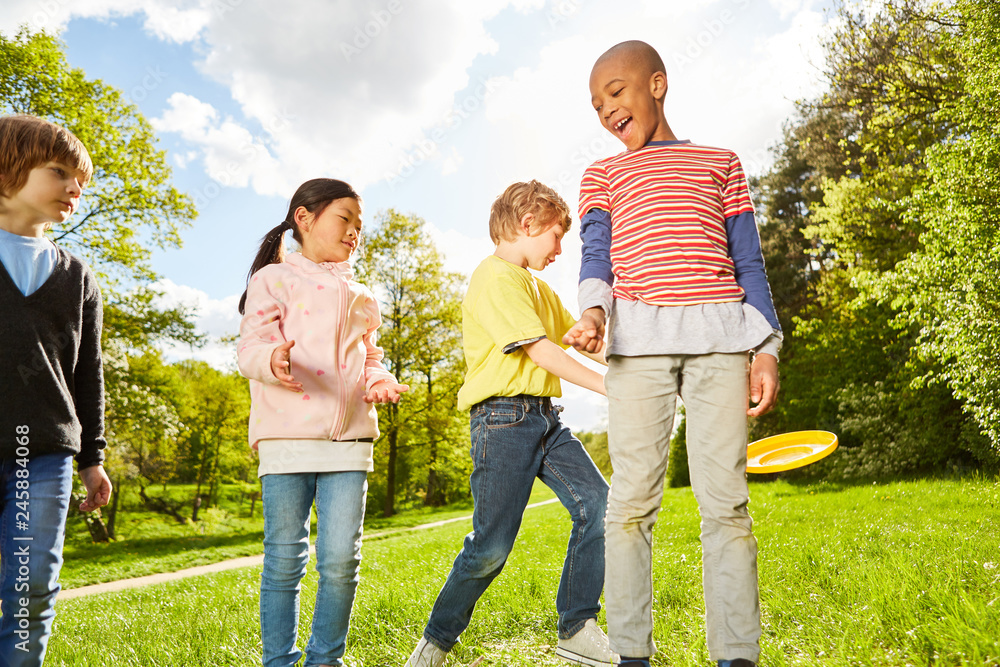 Fototapeta premium Kinder im Kindergarten spielen Frisbee im Park
