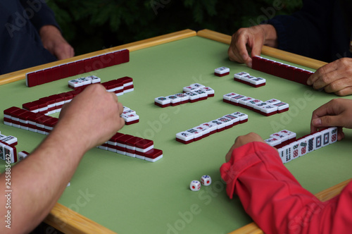 unrecognizable people playing mahjong game photo