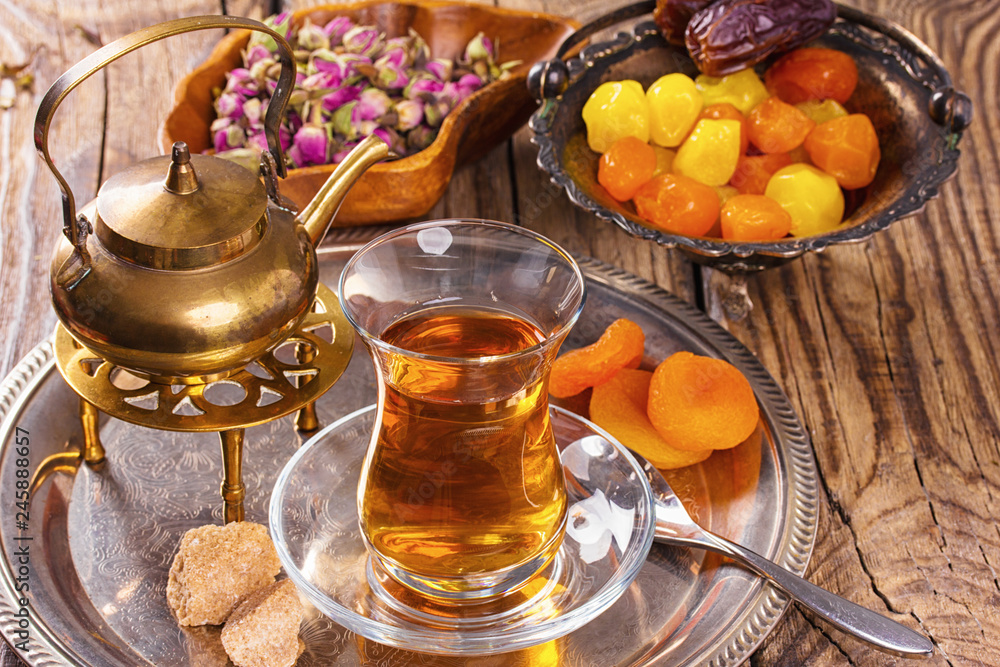 various dried fruits and Turkish tea in Armudu glass on wooden table. various dried fruits and Turkish tea in Armudu glass on wooden table.