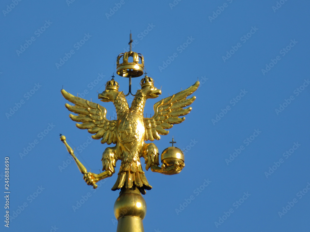 Double-headed eagle, symbol of Russia isolated on blue sky background. Golden russian emblem on the top of tower on Red square in Moscow Double-headed eagle, symbol of Russia isolated on blue sky background. Golden russian emblem on the top of tower on Red square in Moscow