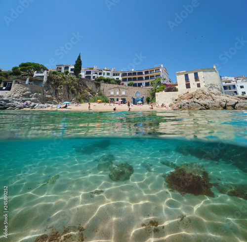 Spain beach in Calella de Palafrugell village, split view half over and under water, Costa Brava, Mediterranean sea, Catalonia
