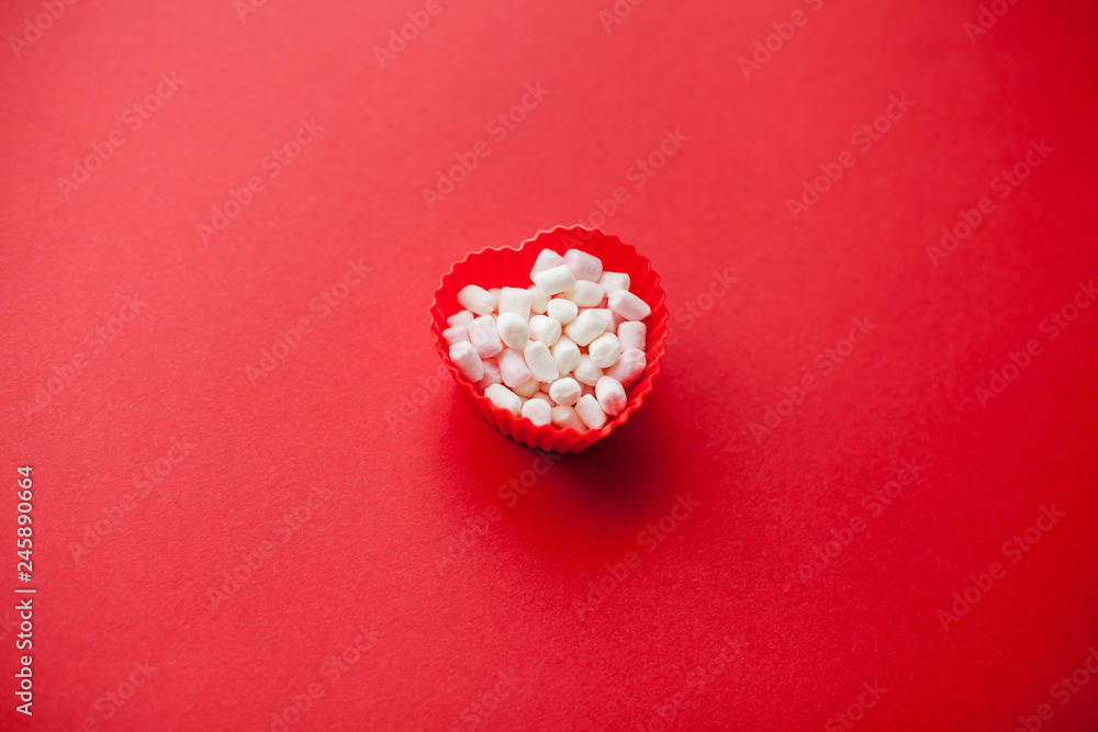 Red heart shape with marshmallows on a red background. Valentine's Day. Love. Holiday. Red heart shape with marshmallows on a red background. Valentine's Day. Love. Holiday.