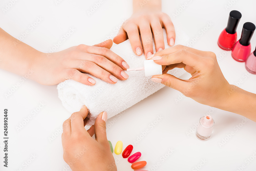 Cropped view of manicurist using nail polish and nail palette Cropped view of manicurist using nail polish and nail palette