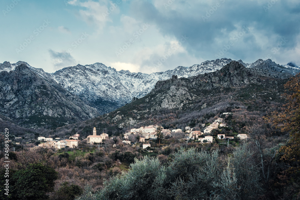 Feliceto village and snow covered mountains in Corsica