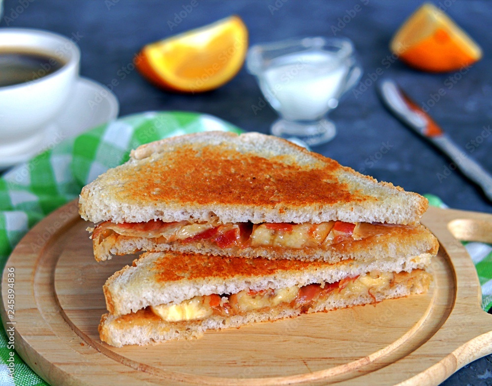Sandwiches with peanut butter, banana and fried bacon on a wooden board. Sandwiches with peanut butter, banana and fried bacon on a wooden board.