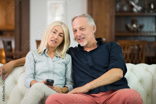 Mature couple watching television in their apartment © Minerva Studio