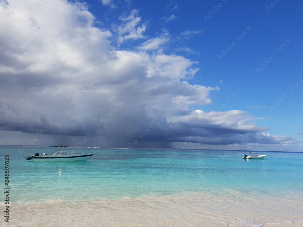 boats in caribbean sea under stormy clouds