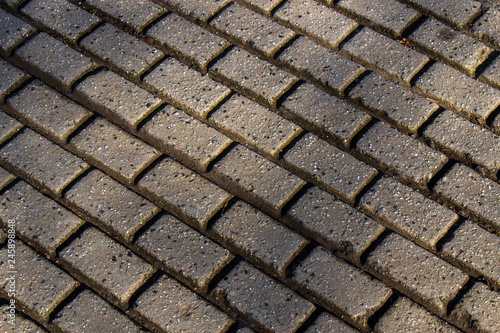 Rectangular cobblestone pattern on the street. Abstract background of grey cobble pavement.