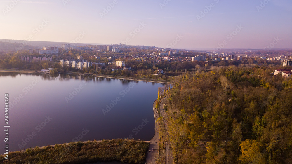 Aerial view of the autumn city park near the lake.