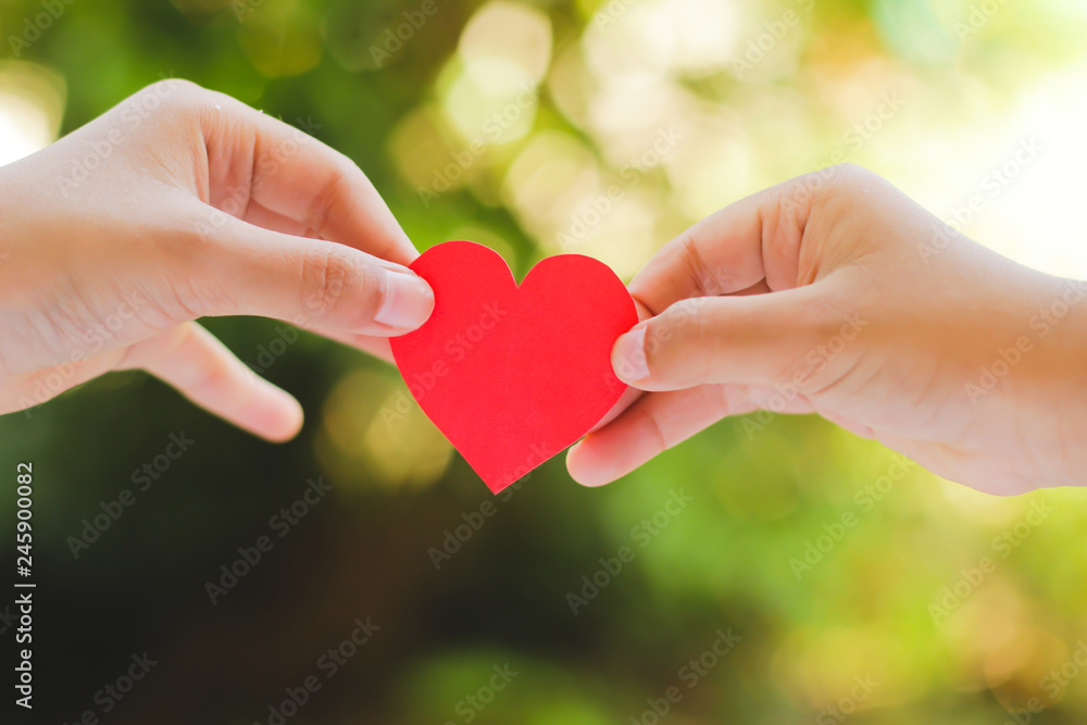 Close up hand of children holding mini heart on green background. Close up hand of children holding mini heart on green background.
