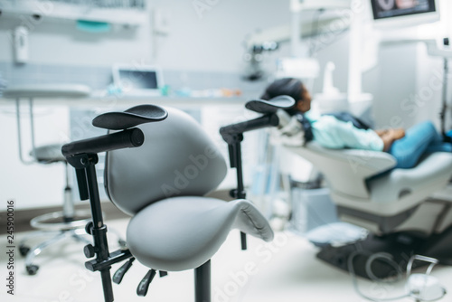 Patient on chair in dental clinic, back view