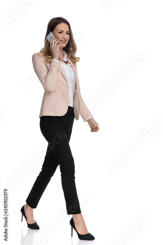 young businesswoman talking on the phone steps to side