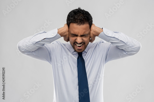 Obraz na plátne business, stress and people concept - screaming indian businessman covering ears