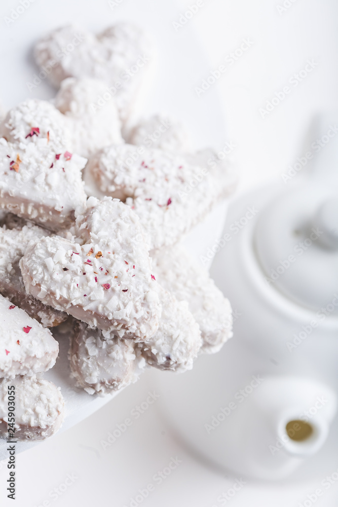 Valentine's day white coconut heart shaped cookies with red and pink heart sprinkles. Copy space Valentine's day white coconut heart shaped cookies with red and pink heart sprinkles. Copy space