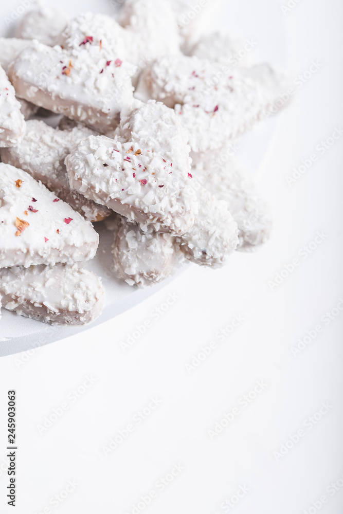 Valentine's day white coconut heart shaped cookies with red and pink heart sprinkles. Copy space Valentine's day white coconut heart shaped cookies with red and pink heart sprinkles. Copy space