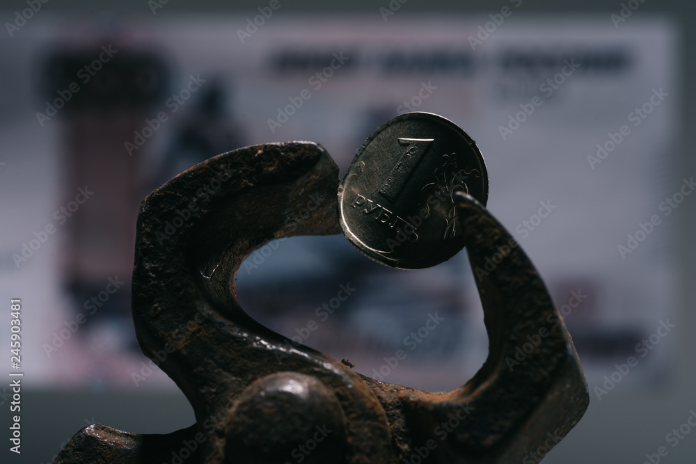 close-up view of iron vise tool with one ruble coin