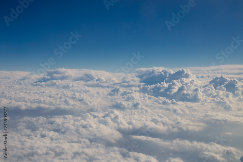 Skyline view above the clouds from airplane. © Olga Ev