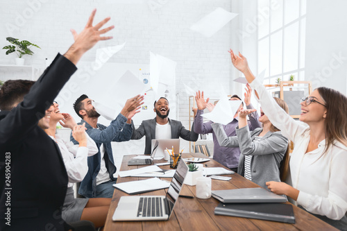 Happy group of business people throw documents