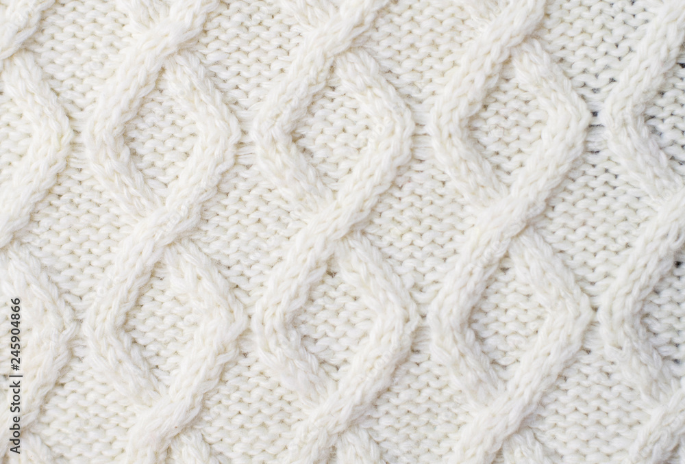 Fotka „Sweater or scarf texture large knitting. Knitted jersey background  with a relief pattern. Braids in knitting. Wool hand-knitted or machine  knitting pattern. Fabric Background.“ ze služby Stock | Adobe Stock