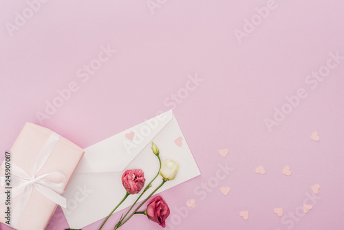 top view of envelope, gift box, flowers and paper hearts isolated on pink © LIGHTFIELD STUDIOS
