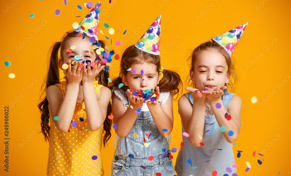 happy birthday children girls with confetti on yellow background - obrazy, fototapety, plakaty 