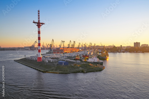 View of the sunset at the port with the mast of navigation equipment and cargo berth of ships, sunrise