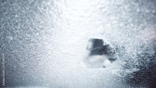 Color footage of a person scraping the ice on a car's windshield.
