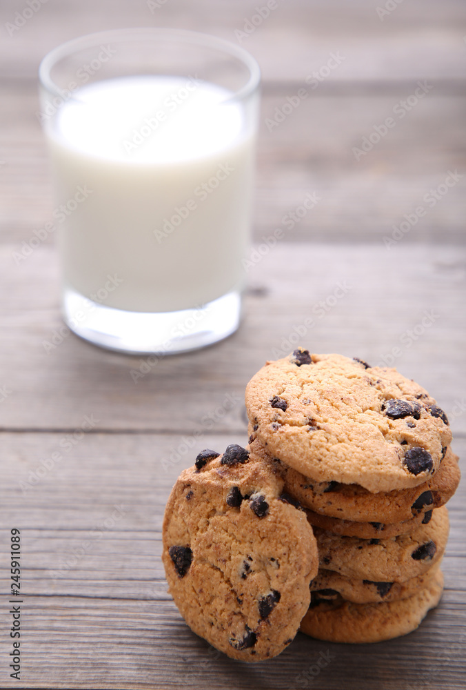 Glass of milk and chocolate cookies on grey background Glass of milk and chocolate cookies on grey background