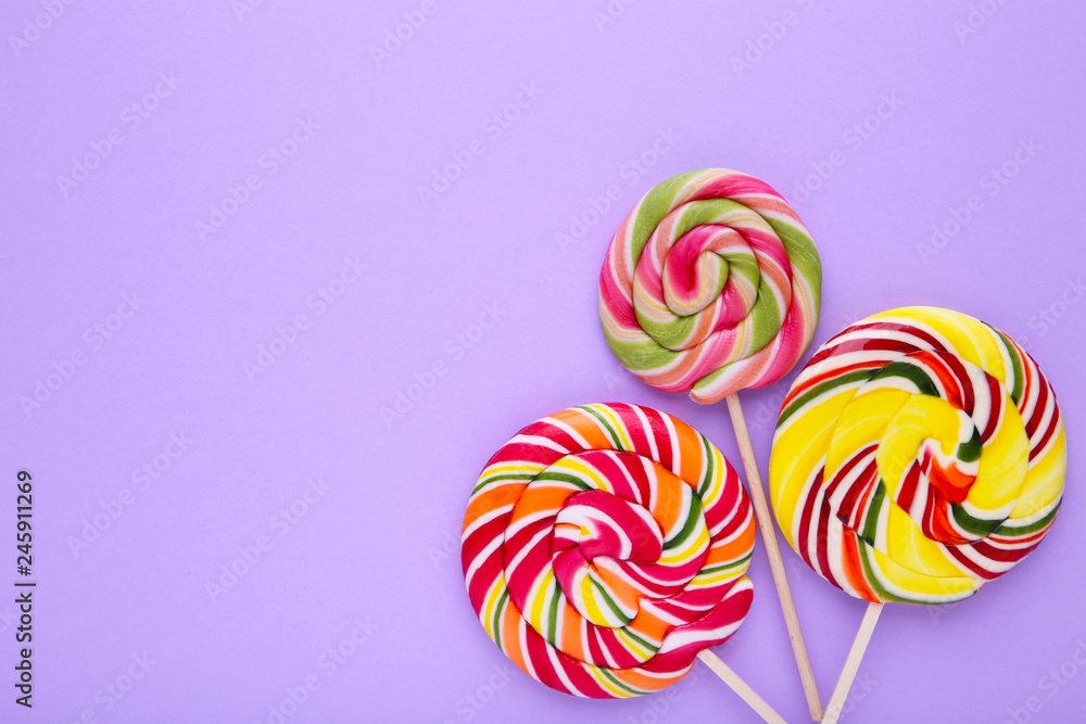 Colorful lollipops on purple background, sweets candy concept