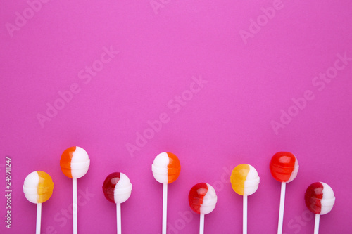 Many colorful lollipop on pink background. sweet candy concept © Mouse family
