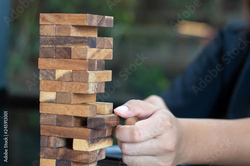 Growing business concept. Business Woman picking domino blocks for filling the missing dominus and protect domino to fail. photo