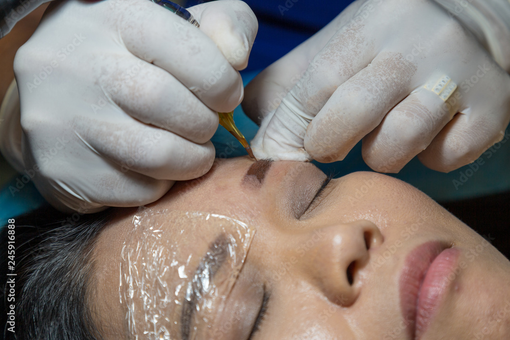Naklejka premium Tattoo eyebrow by Beautician professional