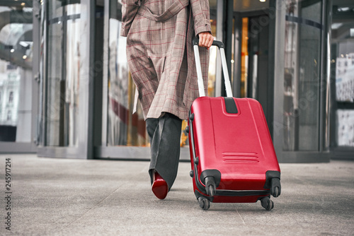 Close up of woman carrying suitcase at the airport terminal © Friends Stock