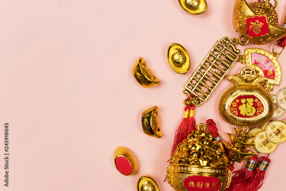 Fototapeta premium Happy Chinese New Year decoration on a pink background. Amulet of wealth and lucky. Calligraphy mean rich. Flat lay, Top view - Image.
