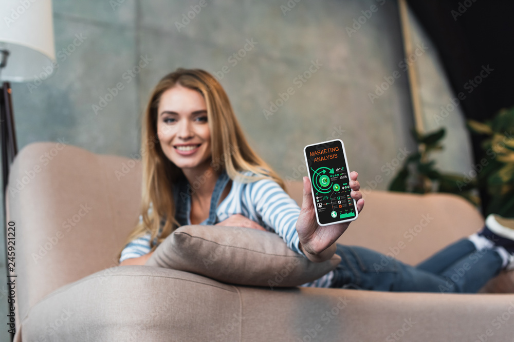 Selective focus of smartphone with marketing analysis app in hand of beautiful woman Selective focus of smartphone with marketing analysis app in hand of beautiful woman