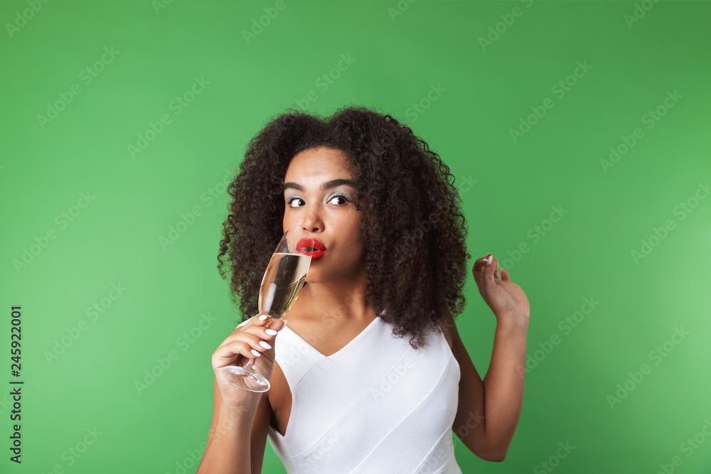 Fototapeta premium Cheerful young african woman wearing dress celebrating