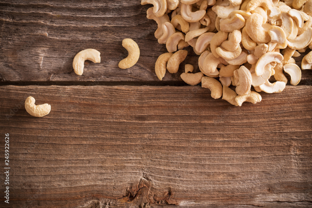 Roasted cashews on natural wooden table background Roasted cashews on natural wooden table background