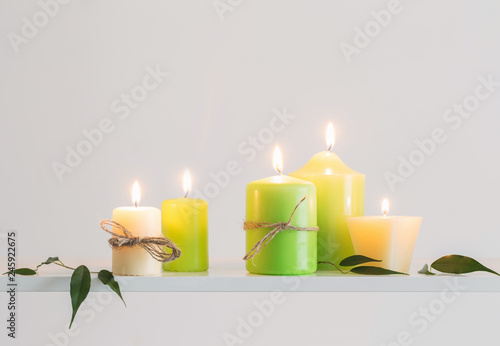 green burning candles on a white background