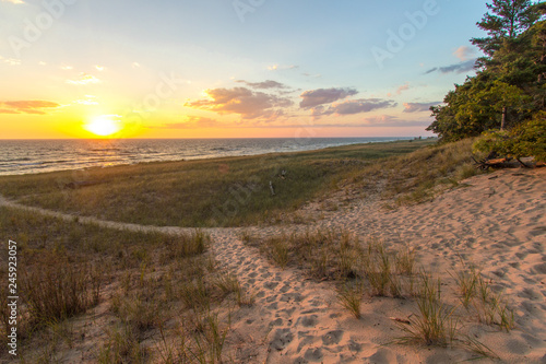 Trail To The Beach. Beautiful sunset horizon with a winding sandy trail through sand dunes. Hoffmaster State Park, Michigan. photo