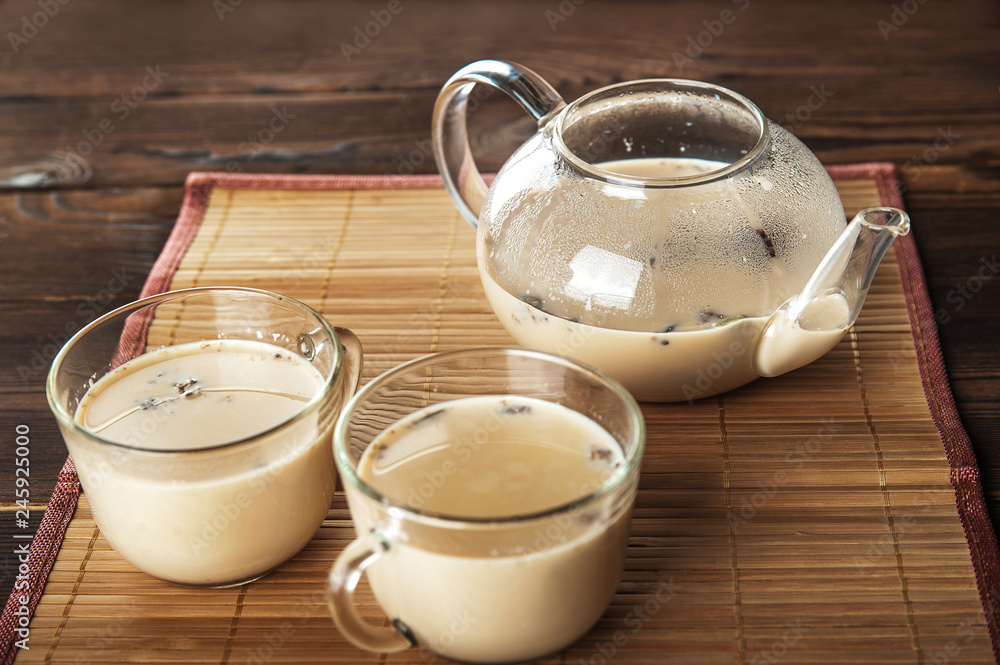 Masala tea on a textural wooden background. A teapot is a transparent ...
