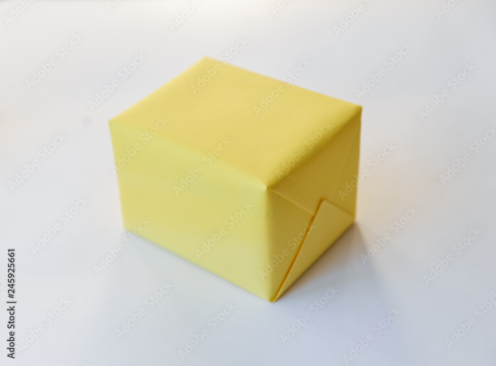 yellow gift box on a white background. winter holidays, pompom from threads, warm. unusual yellow gift box on a white background. winter holidays, pompom from threads, warm. unusual